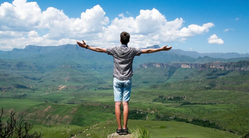 man wearing grey shirt standing on elevated surface