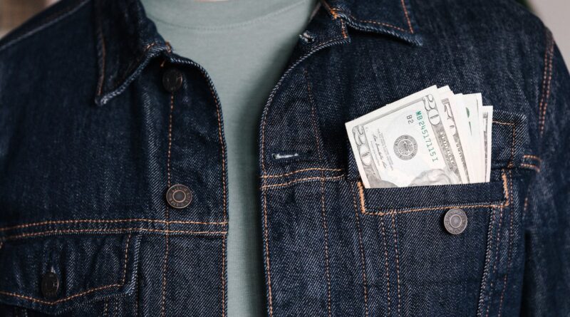 crop man with dollar banknotes in pocket of jacket