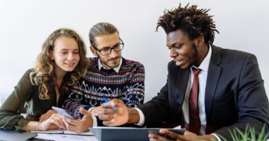 man in black suit jacket sitting beside a couple