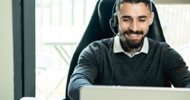 bearded man wearing headphones while working in the office
